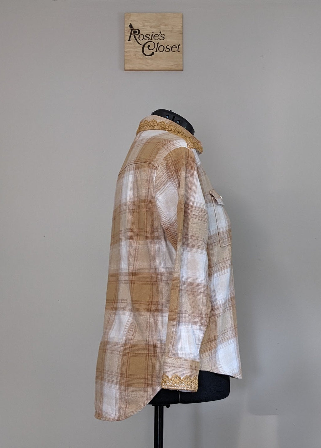 Plaid shirt on a mannequin against a plain wall with 'RC' branding.
