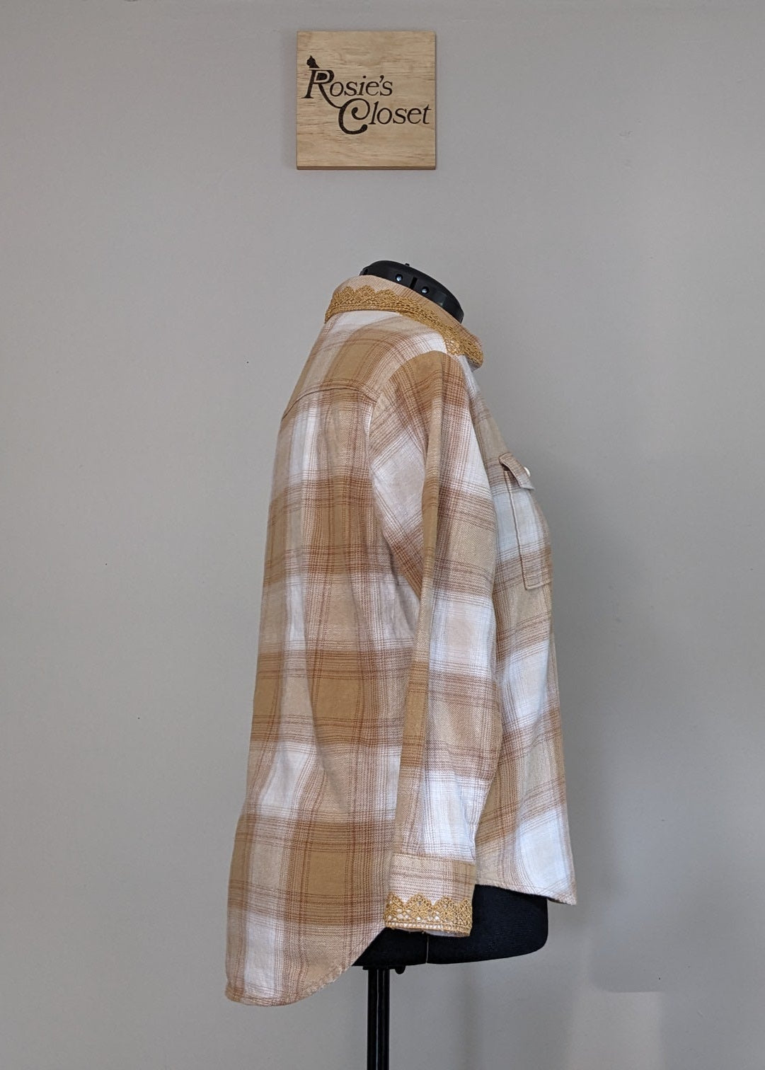 Plaid shirt on a mannequin against a plain wall with 'RC' branding.